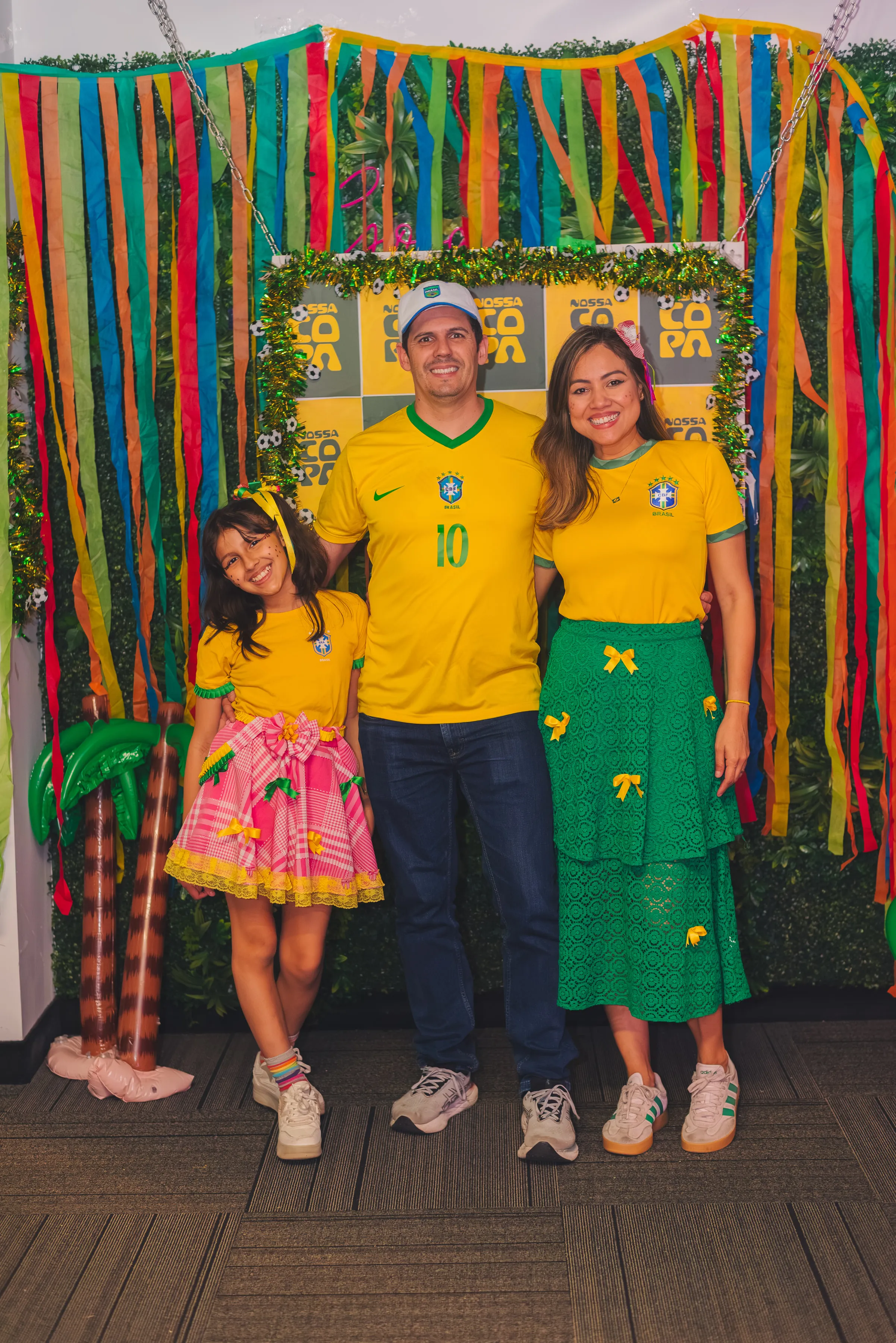 Familia posando con camisetas de Brasil en Nossa Copa.