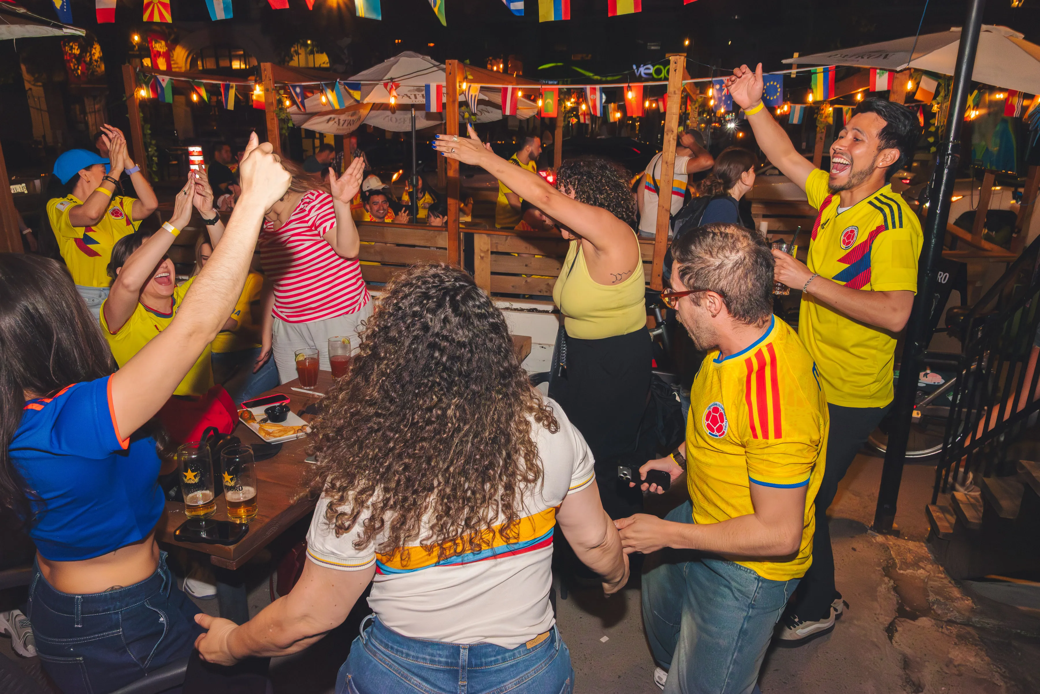 Aficionados de Colombia celebrando frente a la pantalla del partido.